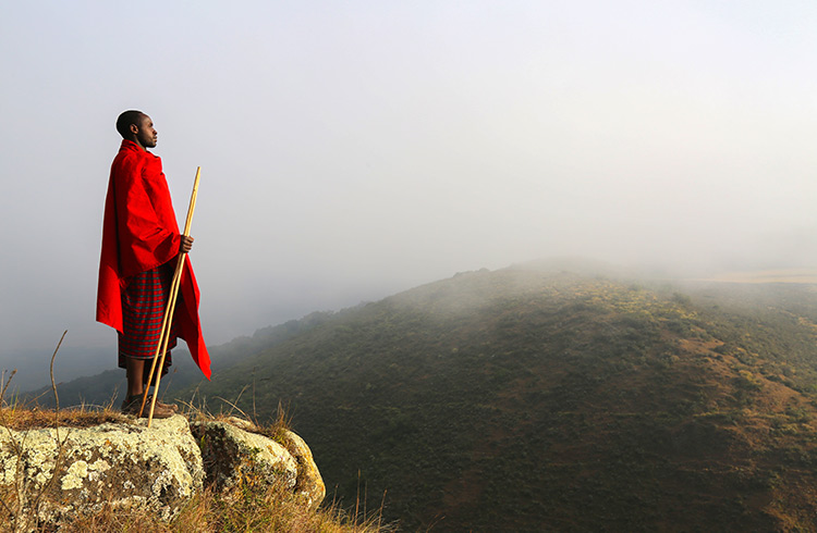 A Maasai warrior looks out over the river valley inside the caldera of Olmoti volcano.