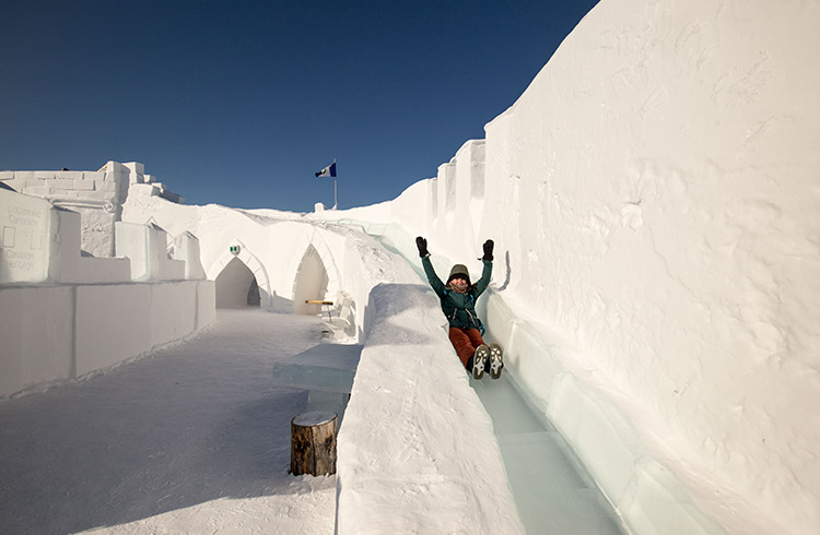 A traveler rides down an ice slide at the Ice Castle in Yellowknife, Canada.