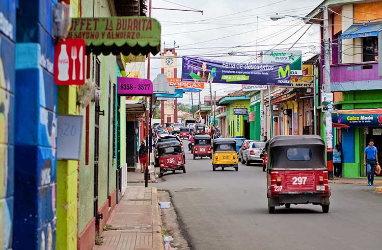 A colorful street full of advertisements and mototaxis in one of the cities of Nicaragua