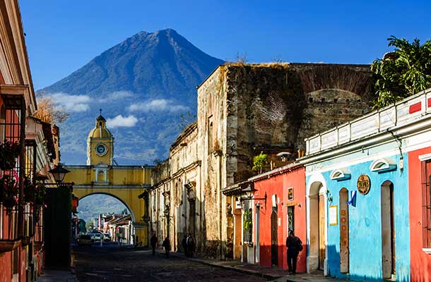 Locals walk to work along Antigua's famous cobblestoned street lined with painted shops