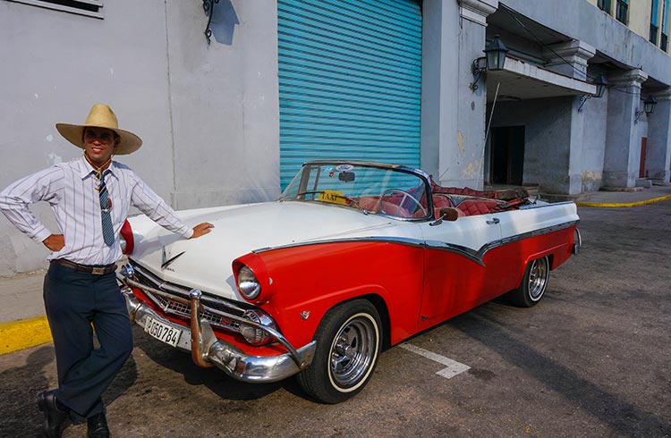A driver stands in front of his classic car in Havana, Cuba.