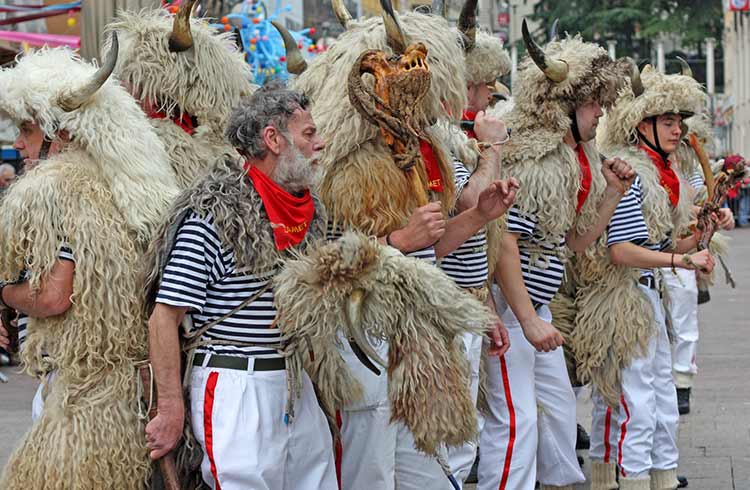 Rijeka Carnival, with men dressed in animal skins ringing cowbells.