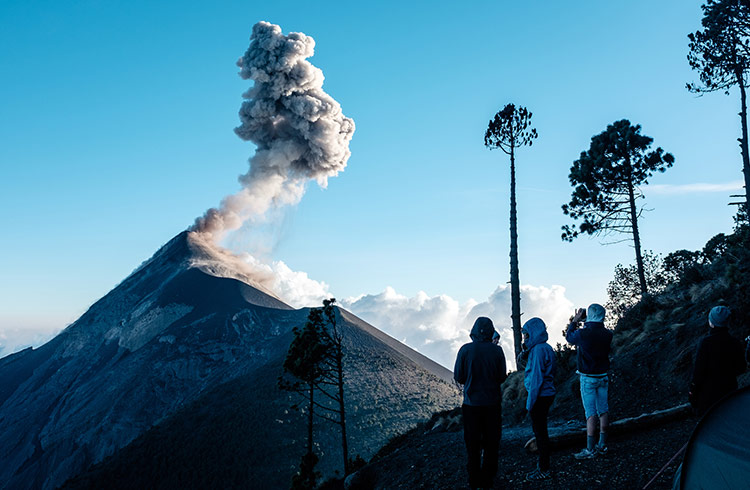 Hikers watch the Fuego volcano erupting from nearby Acatenango.
