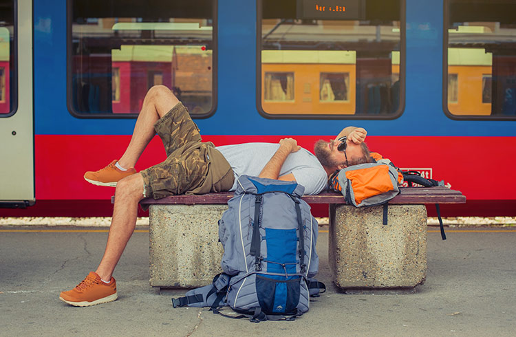 Hungover backpacker asleep on train platform