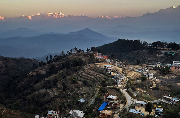 A village in Nepal with the Himalayas as a backdrop.