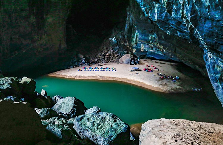 Camping tents on a beach inside Hang En cave.