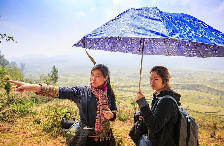 A Hmong woman gives directions to a traveler in Sapa, Vietnam.