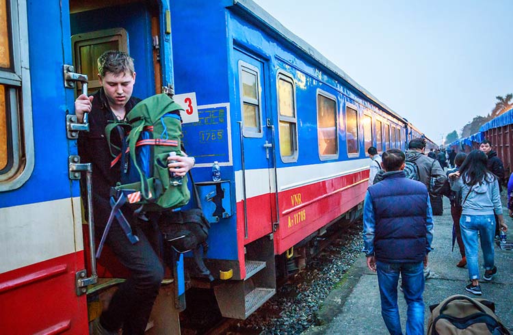 A traveler steps off a train in Vietnam.