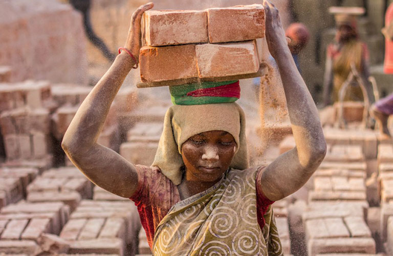 Woman carrying bricks