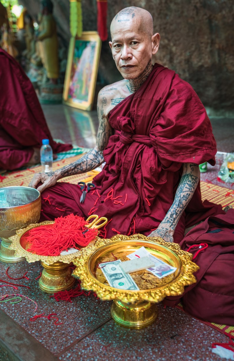 A monk offers blessings to Cambodians while they offer monetary donations.