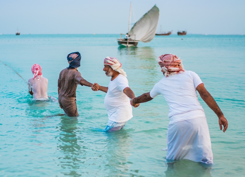 Men from Oman and Saudi Arabia demonstrate camaraderie as the Middle Eastern neighbors join hands to use their united power and strength to draw the fishing nets closer.