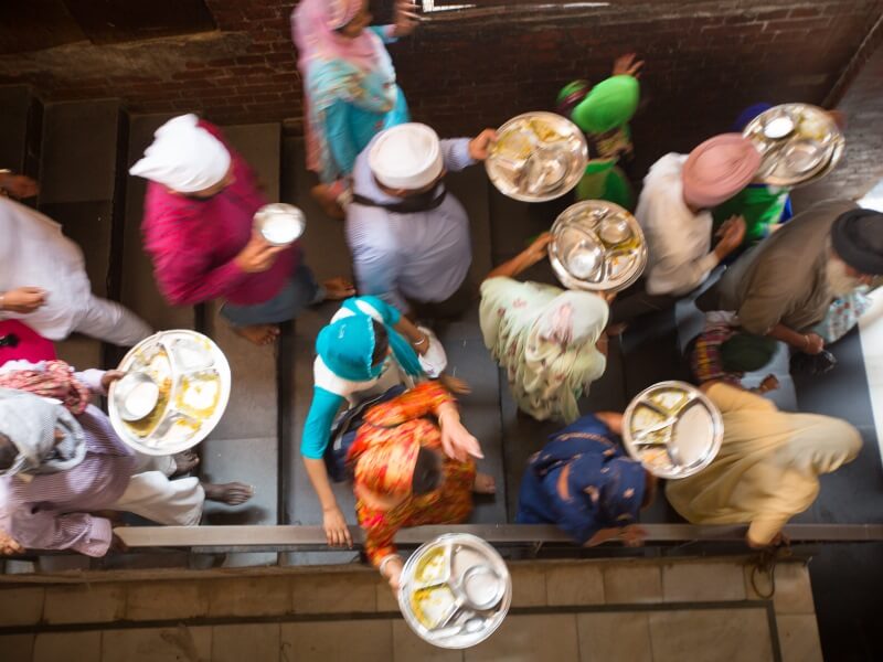 After the communal meal, lines of people carry their metal plates downstairs to be handed off to the dishwashers.