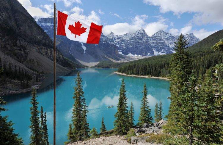 The Canadian National flag set against the Rocky Mountains of Banff National Park