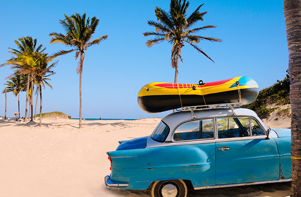 A vintage car at a beach in Cuba