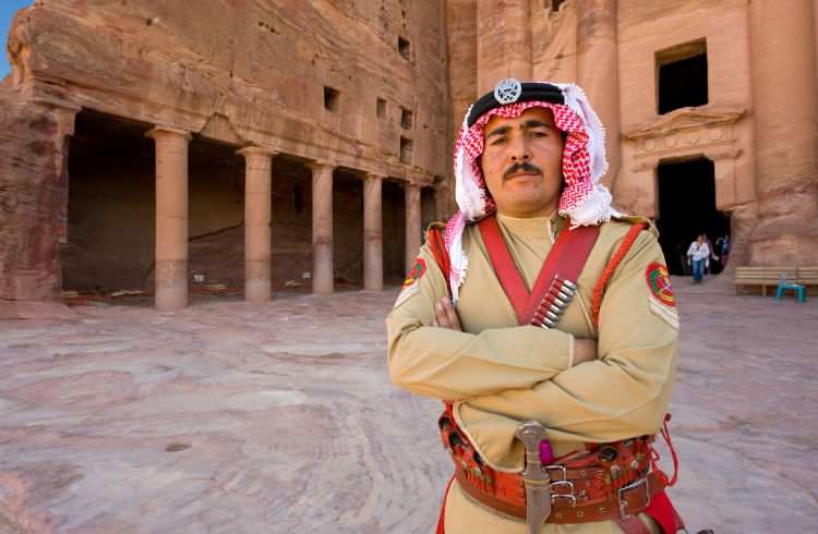 A guard in ancient costume in front of one of the royal tombs in Petra in Jordan