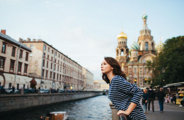 A woman standing on the river embankment in St. Petersburg, Russia