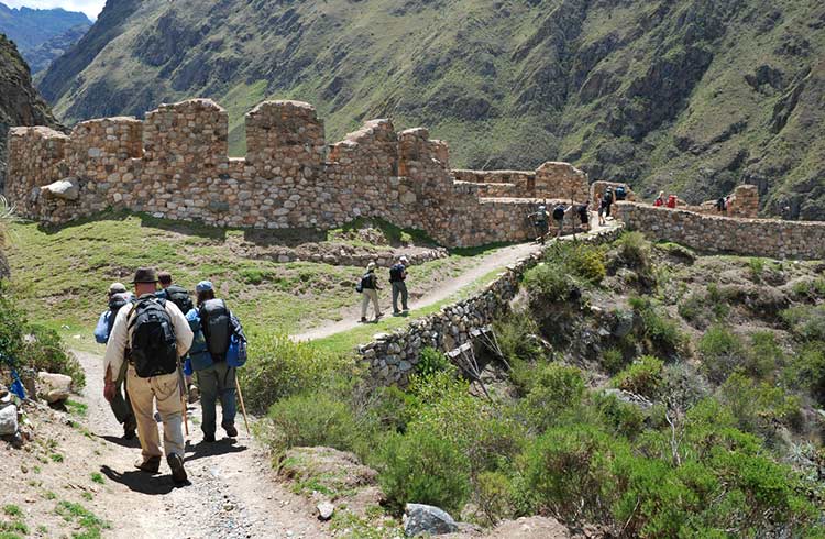 Several hikers on the classic Inca Trail in Peru head toward the Incan ruins of Willkarakay