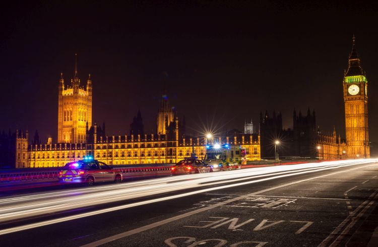 Police cars and an ambulance on Westminster Bridge, London at night