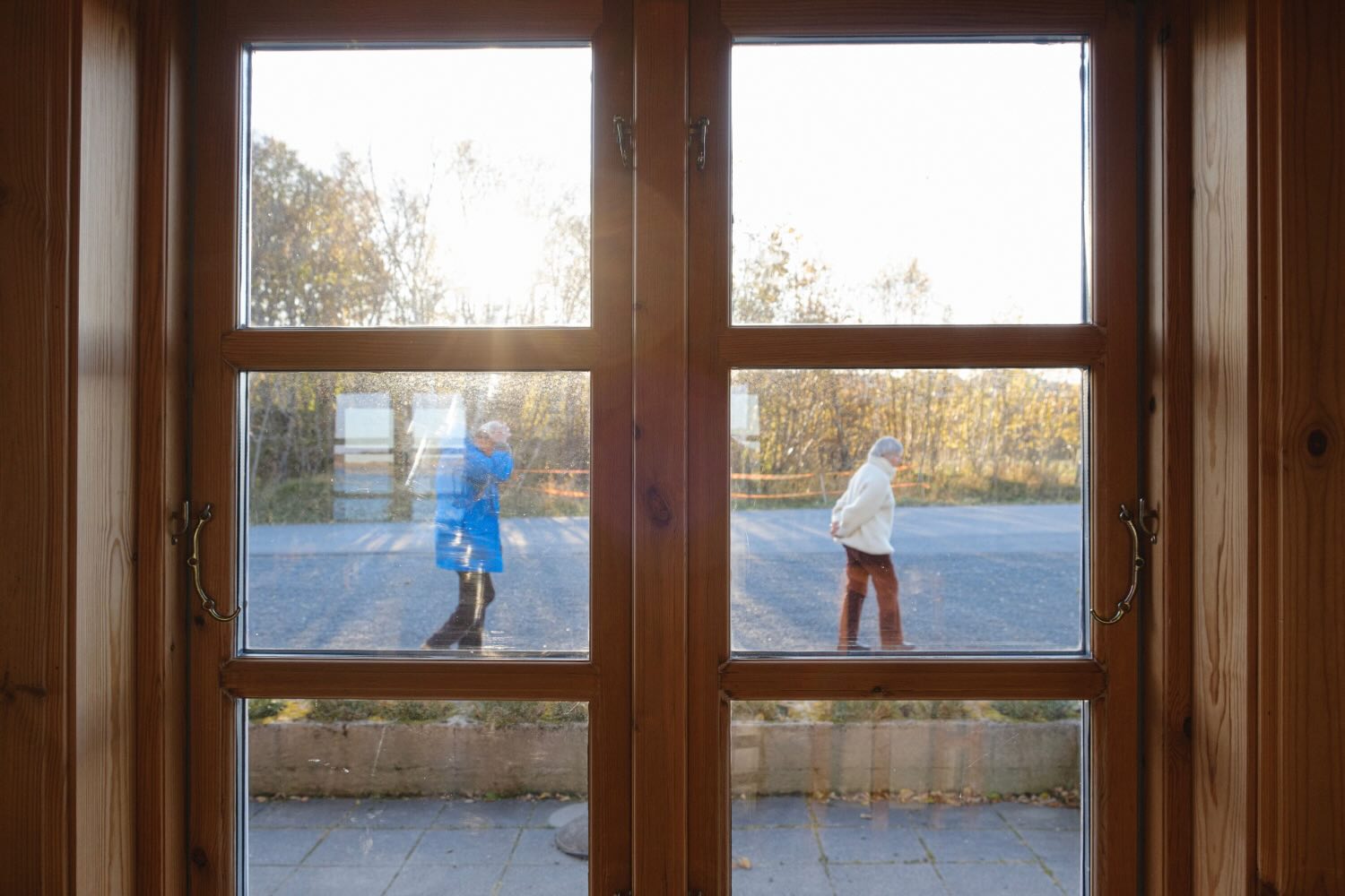 Two people seen walking through closed glass doors
