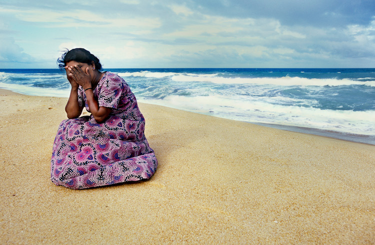A woman overcome with devastation on the beach after the 2005 tsunami in Sri Lanka.