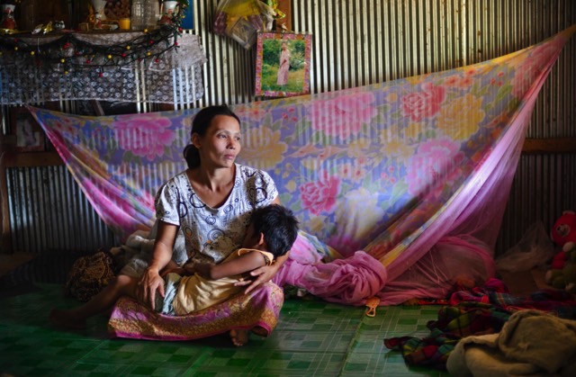 A Burmese woman holds her child in a refugee camp