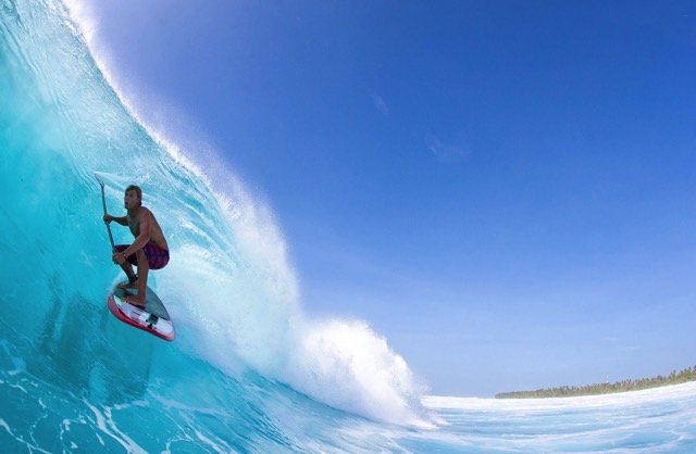 a man surfing a wave on a paddle board