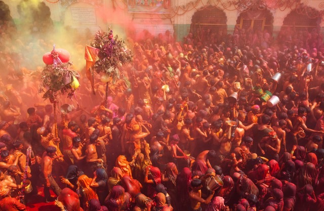 crowd of people colored in red and yellow powder