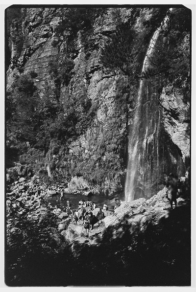 A tall waterfall coming off the side of a mountain