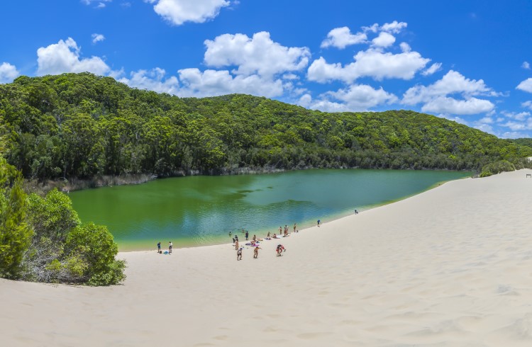 Swimmers and sand dunes at Lake Wabby, Fraser Island, Queensland.