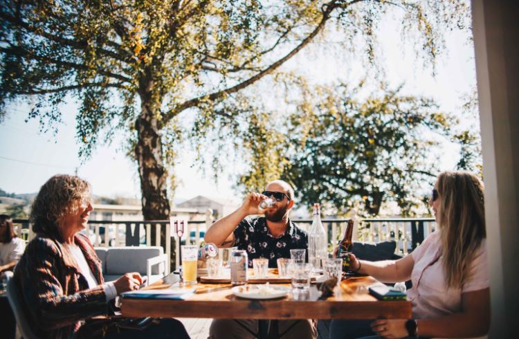 Three people dining at an outdoor table at a taphouse in Tasmania.