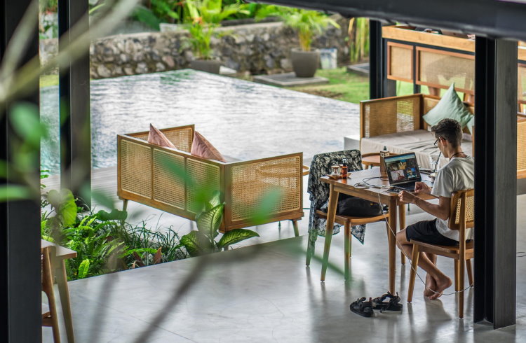 A digital nomad uses a laptop computer at a coworking hostel in Bali.