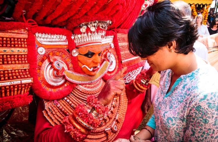 Avatars in red headdresses, Theyyam ceremony, Kerala, India.