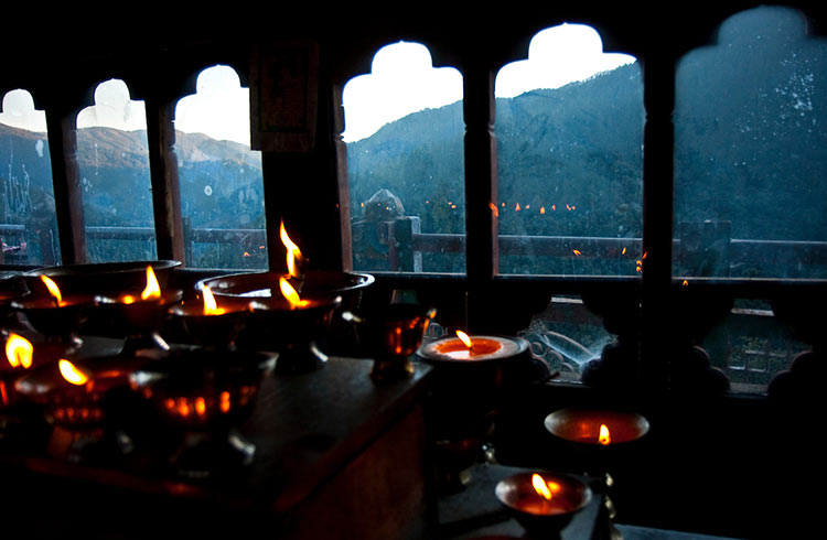 Candles flicker inside a temple in Bhutan.