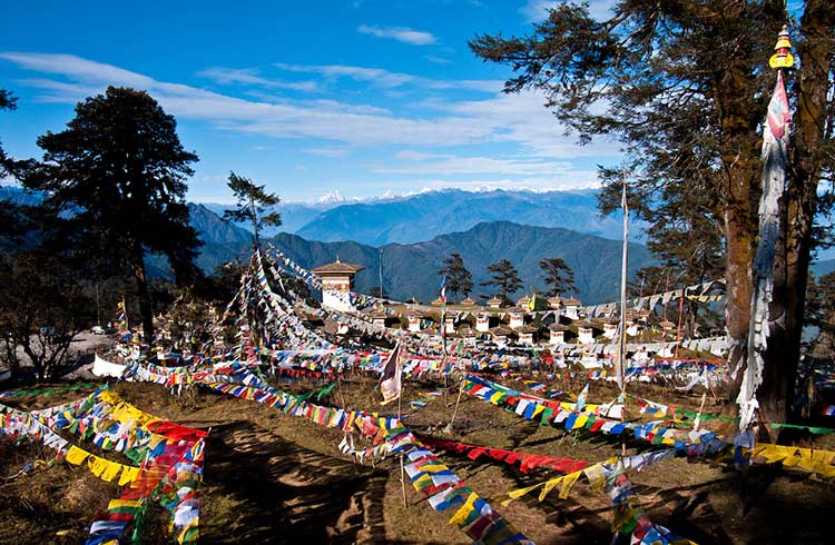 Colorful prayer flags strung across a mountaintop in Bhutan.