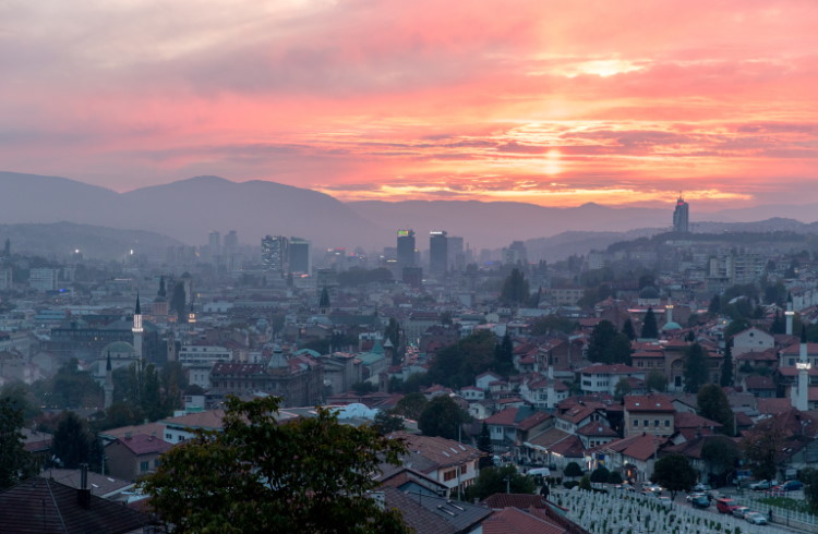 The city of Sarajevo at dusk, seen from a hillside.