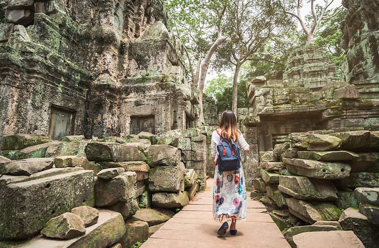 Young woman traveler visiting in ta prohm temple at Angkor Wat complex