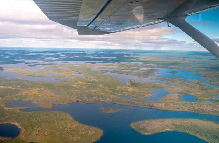 An aerial view of dozens of lakes stretching to the horizon in northern Manitoba, Canada.