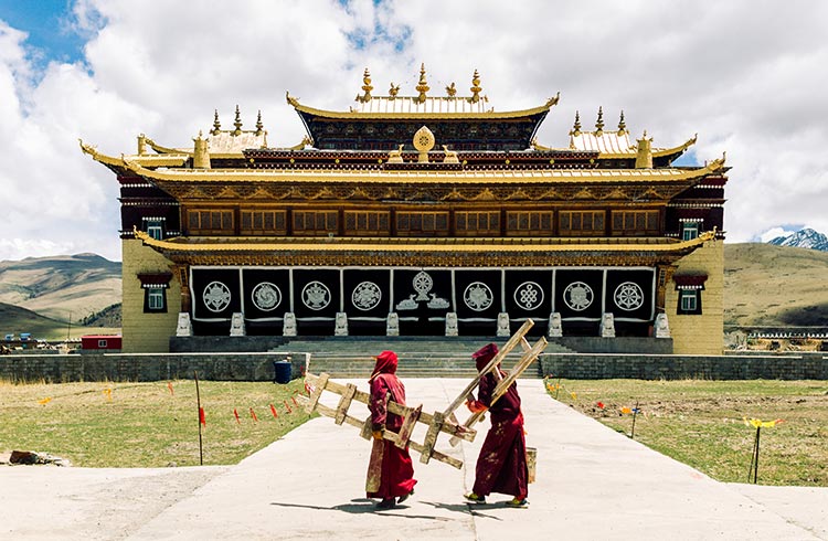Tibetan monks by traditional Tibetan monastery by Tagong grassland in Litang