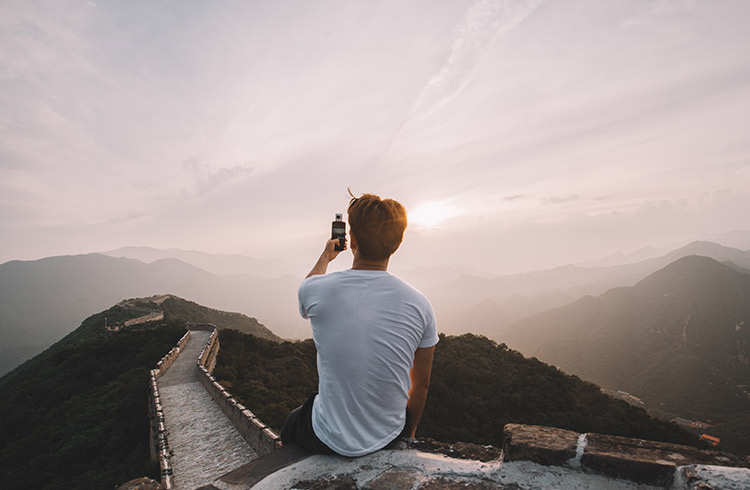 A man using a phone on the Great Wall of China