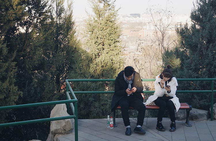 Two people using their phones in the Forbidden City, Beijing