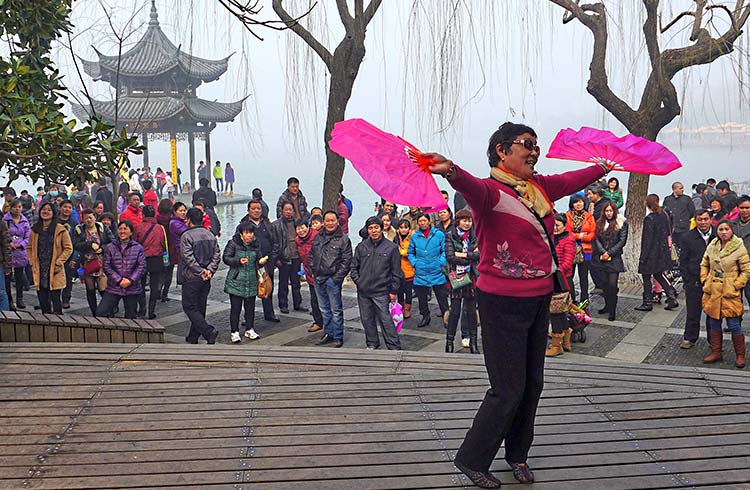 A woman spins around in a crowd of people during West Lake Lotus Festival
