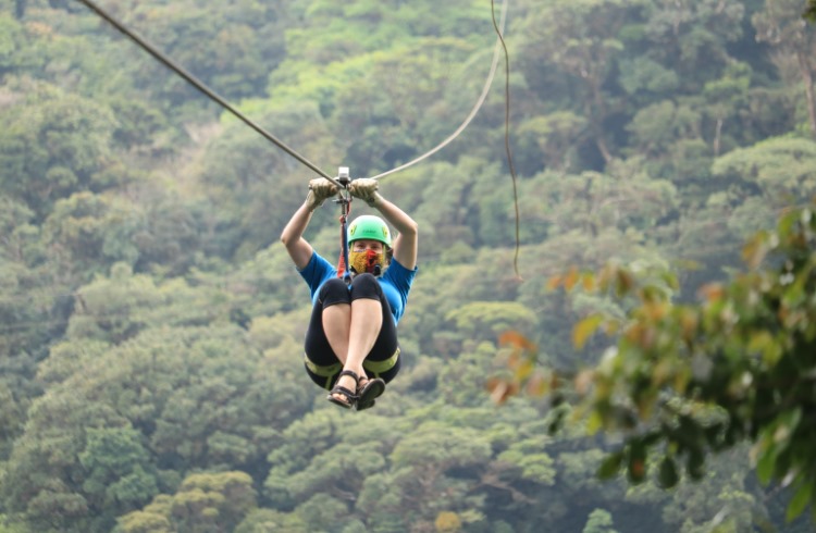 A woman rides a zip line through the cloud forest in Monteverde, Costa Rica.