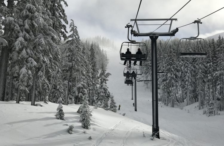 Spaced apart for social distancing, skiers ride the chairlift at Mount Bachelor ski resort.