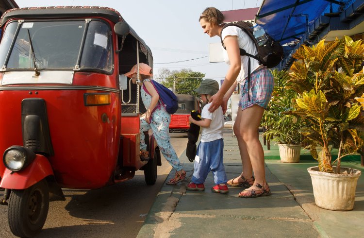 Mother and children travelers getting into a tuk-tuk