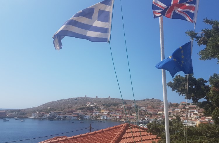 Flags wave over a tile roof on the Greek island of Halki.