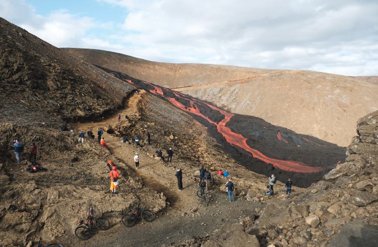 Tourists gaze at the red lava flow at the Geldingadalir eruption.