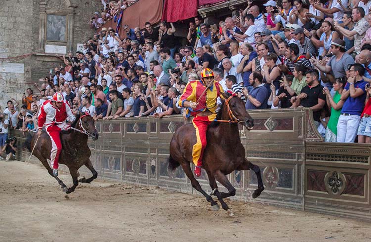 Jockeys compete at the historical horse race Palio di Siena, in Siena, Italy