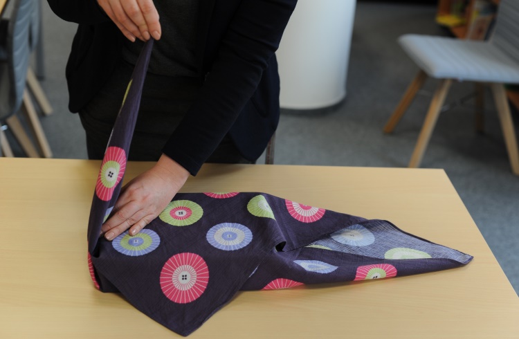 A woman demonstrates the Japanese art of Furoshiki (wrapping items in fabric).