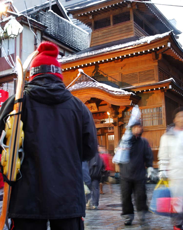 Skiers carry skis through the streets of Nozawa Onsen, Japan.