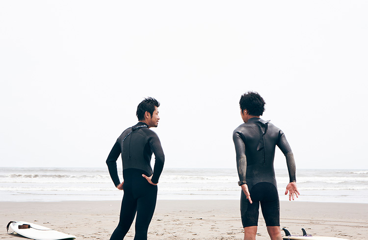 Two surfers have a chat before hopping in to catch a wave in Chiba Prefecture, Japan